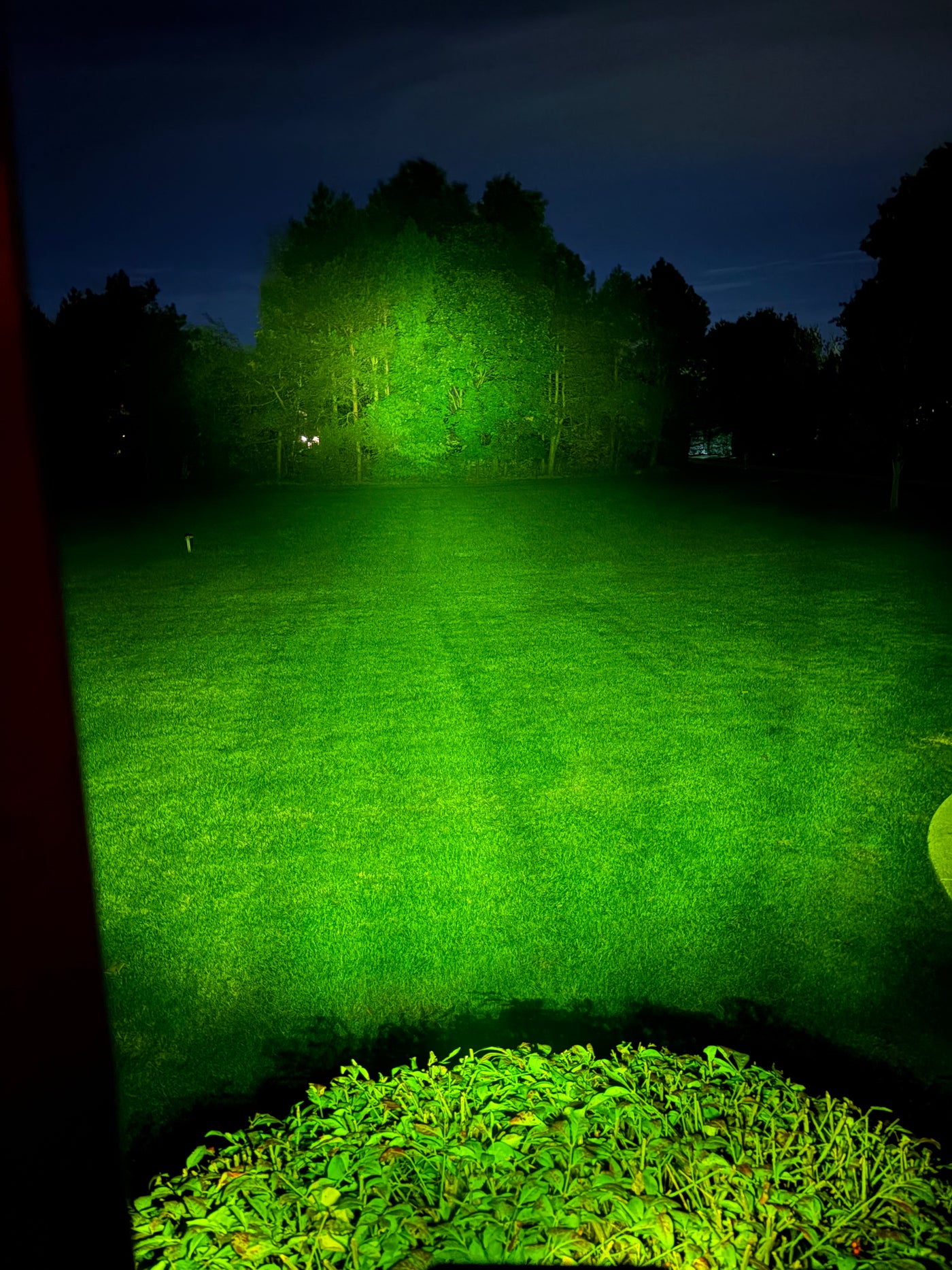 Night beam test of the battery-powered Baja light with green lens lighting up a field